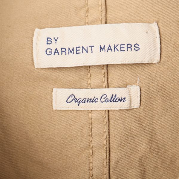 Närbild av etiketter i jackan, By Garment Makers