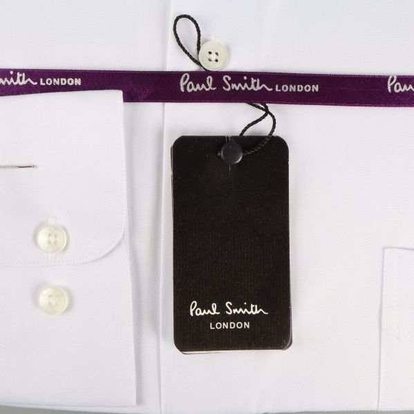 Detalj på skjortans paket Etikett och lila band på skjortan