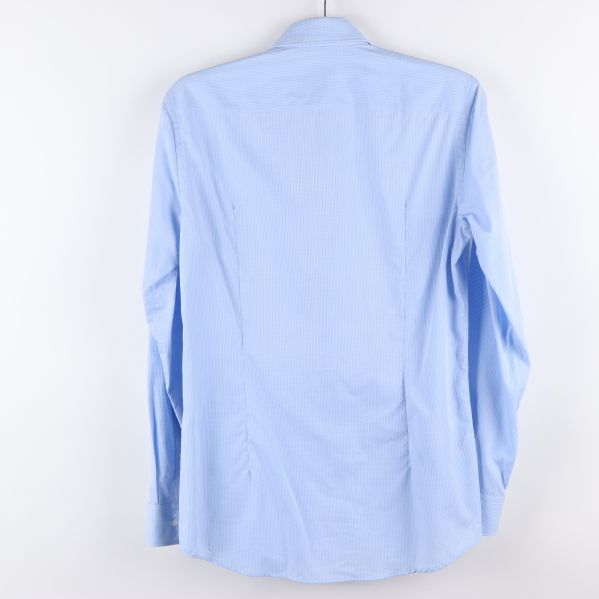 Baksidan av ljusblå skjorta med lång ärm