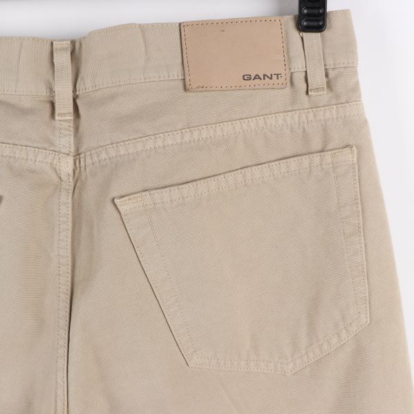 Baksida av beige jeans med två bakfickor