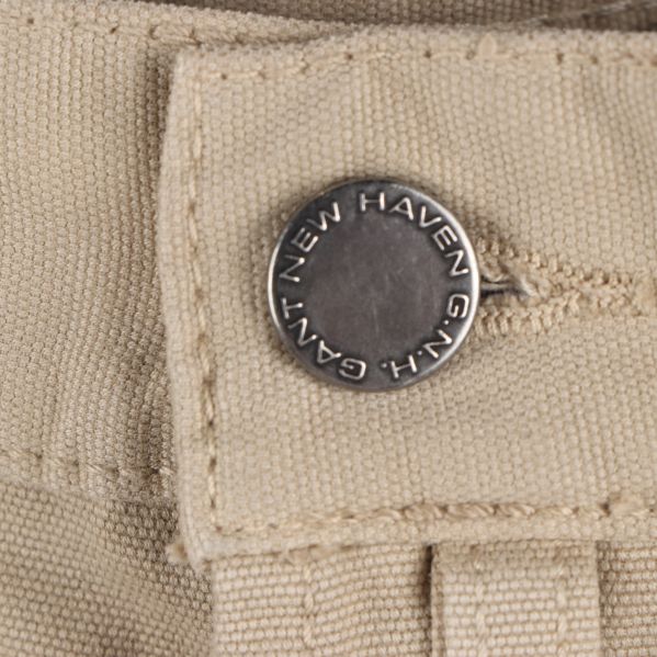 Knapp på beige jeans med GANT-loggan