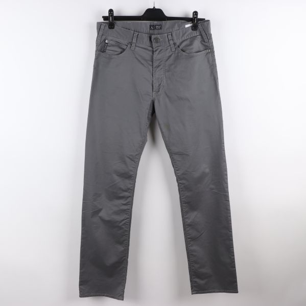 Framsidan av grå jeans med knäppning och fickor