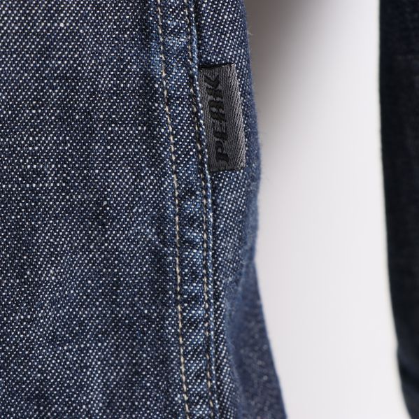 Detaljbild av ena sidan av jeansskjorta 