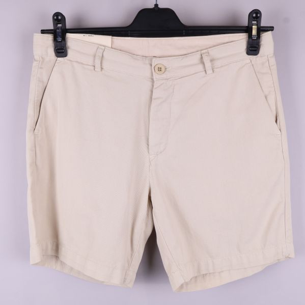 Framsida av beige chinoshorts