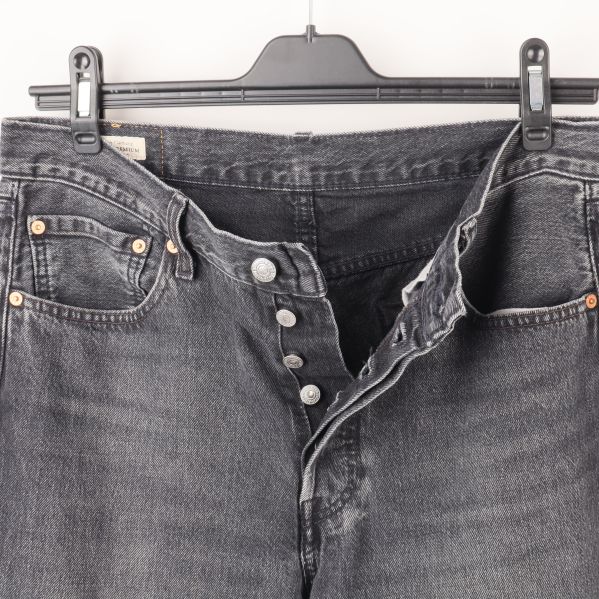 Öppnad knappgylf på svarta jeans