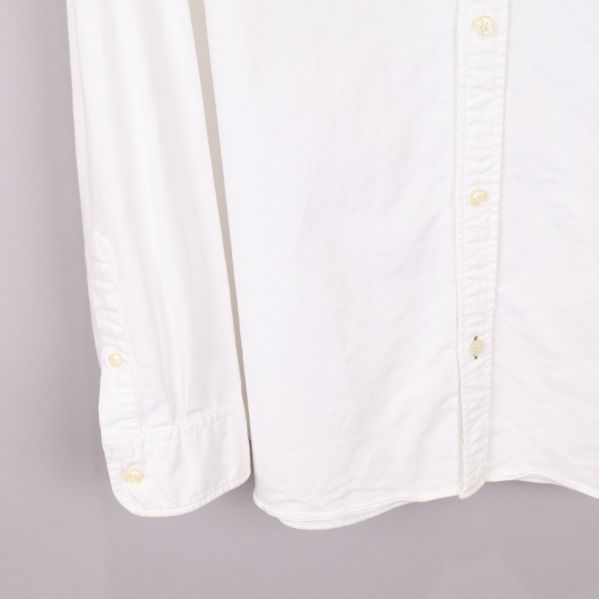 Närbild av skjortans ärm och knappdetaljer