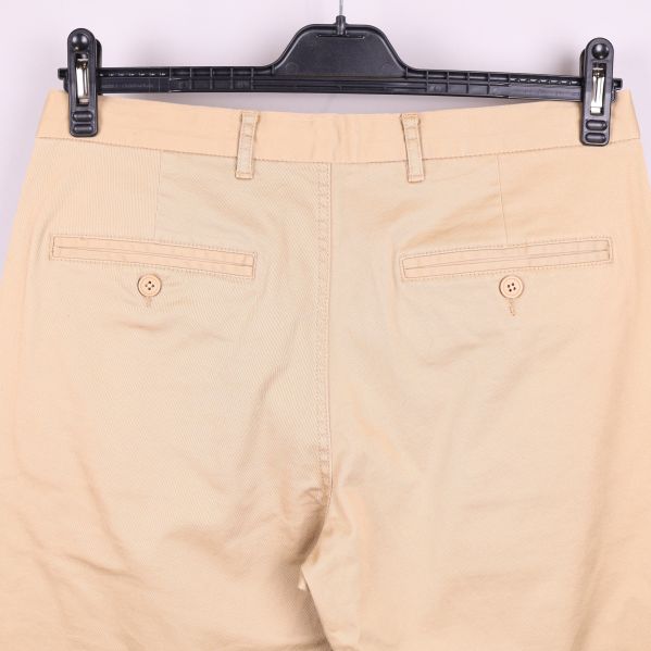 Närbild av chinos bakfickor med knappar