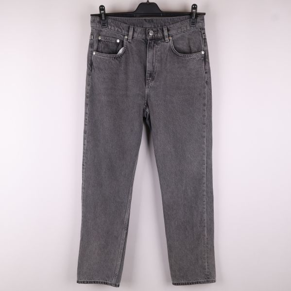 Framsidan av grå jeans 