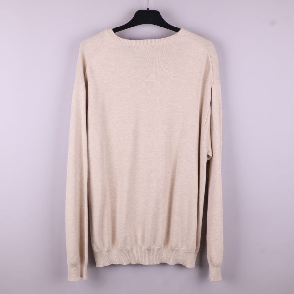 Baksidan av beige V-ringad tröja 