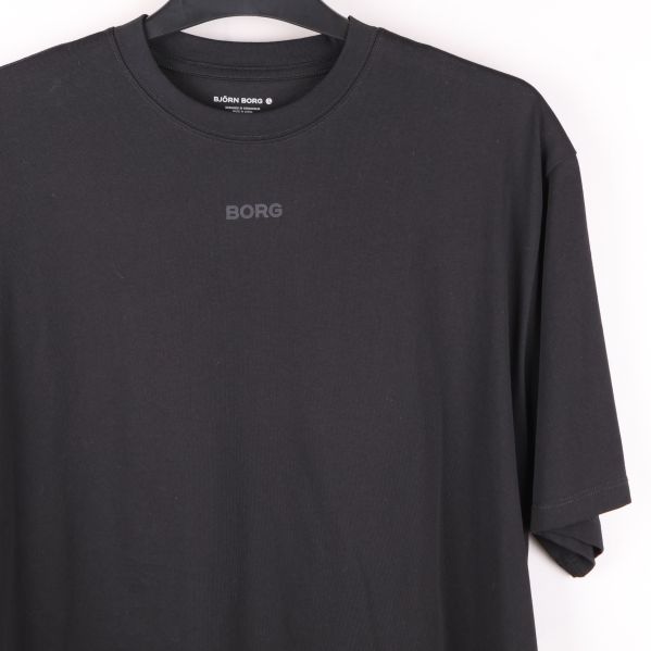 Närbild på bröstet på svart t-shirt med logotryck