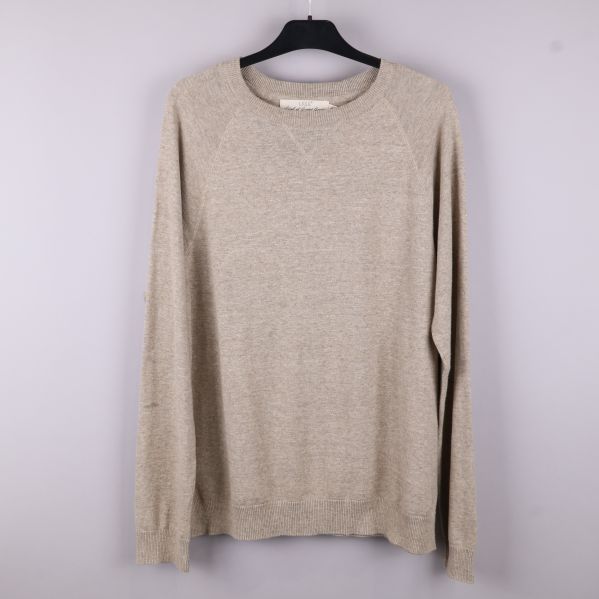 Framsidan av beige stickad tröja