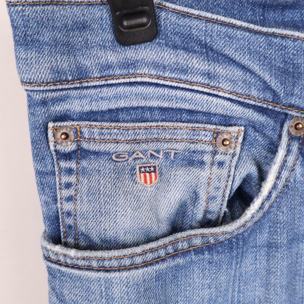 Närbild på en jeansficka med Gant-logotyp