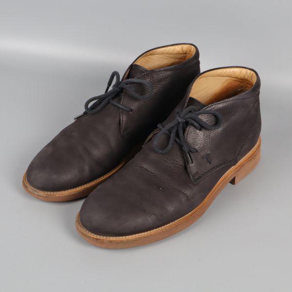 Par mörka chukka boots med ljus sula, snett från sidan