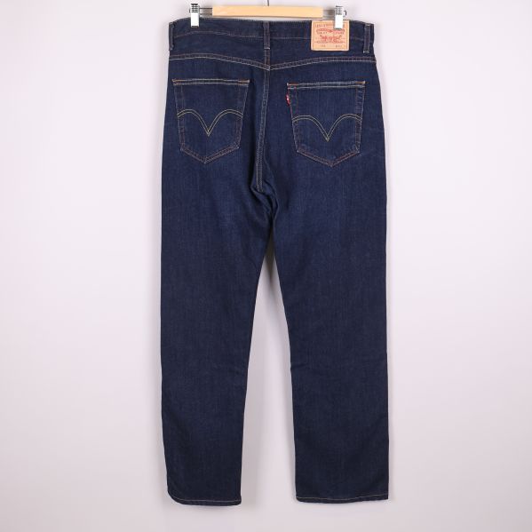 Baksida av jeans med kontrastsömmar och läderpatch