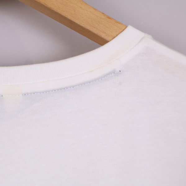 Närbild på halsringningens söm på vit t-shirt