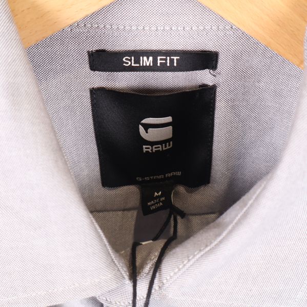Närbild på krage med RAW-logotyp och slim fit-etikett