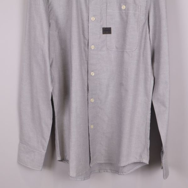 Nedre del av skjorta med ärmslut och knappar i fokus