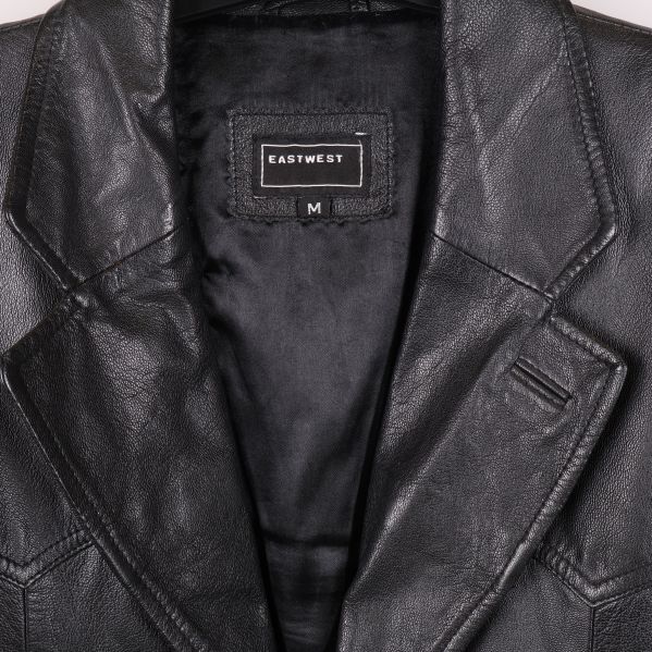 Närbild på krage och märke i skinnkavaj