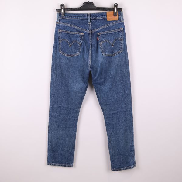 Baksida av blå jeans med synliga fickor och patch