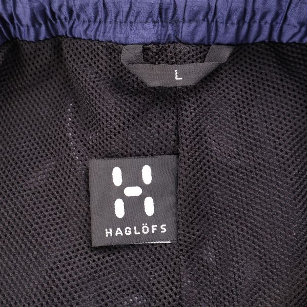 Etikett med Haglöfs logotyp och storlek L på byxan