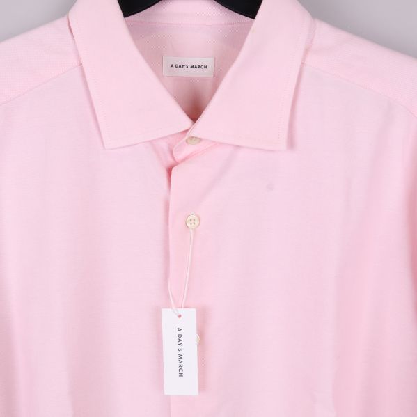 Detalj av skjortkrage med vit etikett och knapp