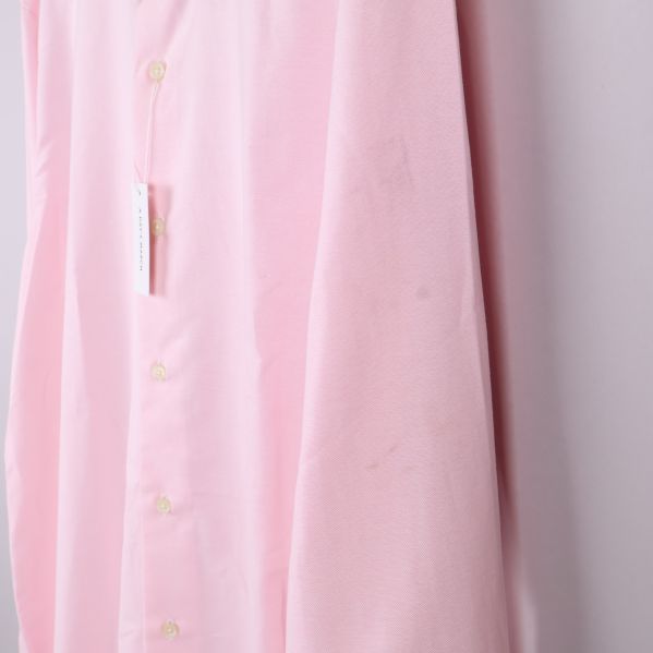 Närbild på ärm med svag fläck på ljusrosa tyg
