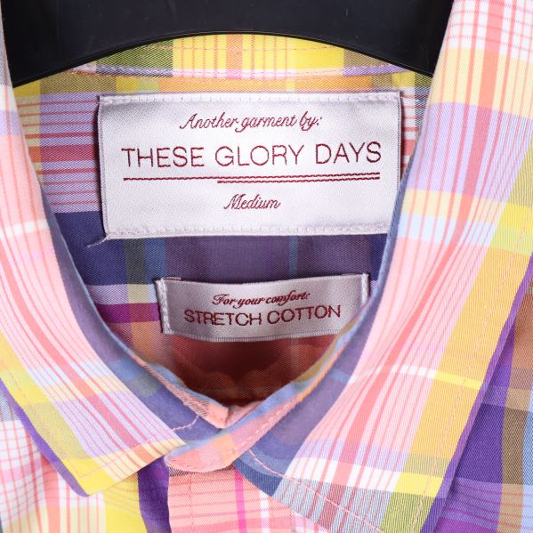 Närbild på etikett med These Glory Days och stretch cotton