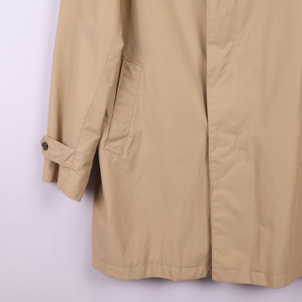 Vänster ärmslut och ficka på beige trenchcoat