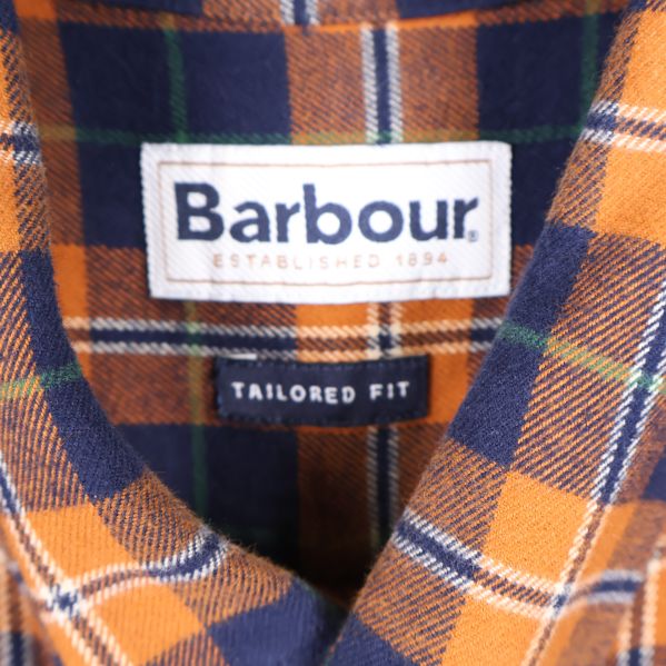 Närbild på Barbour-märke i nacken och tailored fit etikett