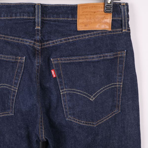 Närbild på jeansens bakfickor och läderpatch