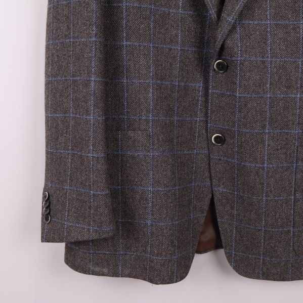 Närbild på kavajens knappar och rutmönster