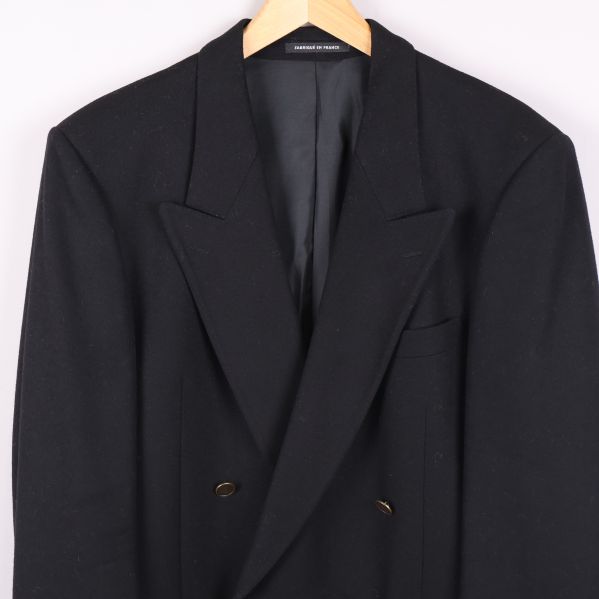 Närbild på kavajens framsida med mässingsknappar och fickor