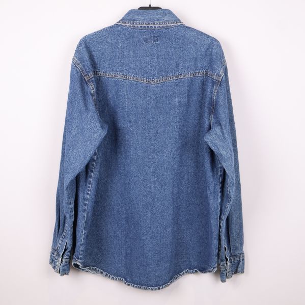 Ryggsida av blå denimskjorta med synliga sömmar