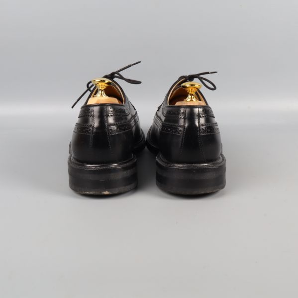 Svarta brogueskor bakifrån, klack synlig