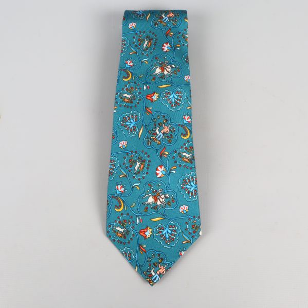 Framsida av slips med turkos bakgrund och blommönster