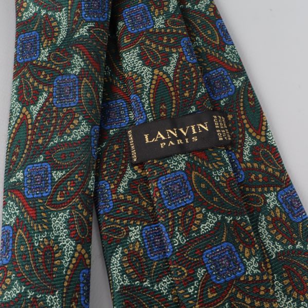 Närbild på Lanvin-logga och paisleymönstrad slips