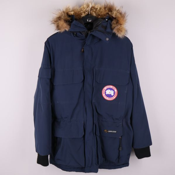 Mörkblå parkas med luva och pälsdetalj, framifrån