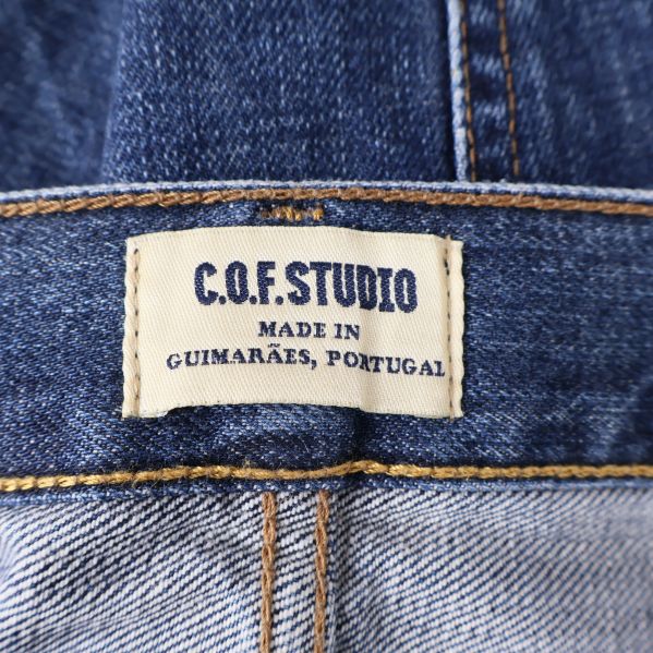 Vit etikett med C.O.F Studio logotyp 