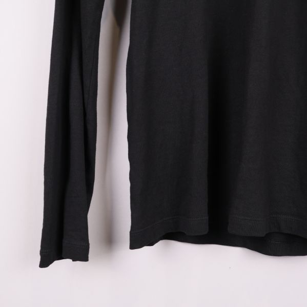 Nederkant och ärmslut på svart långärmad pikétröja