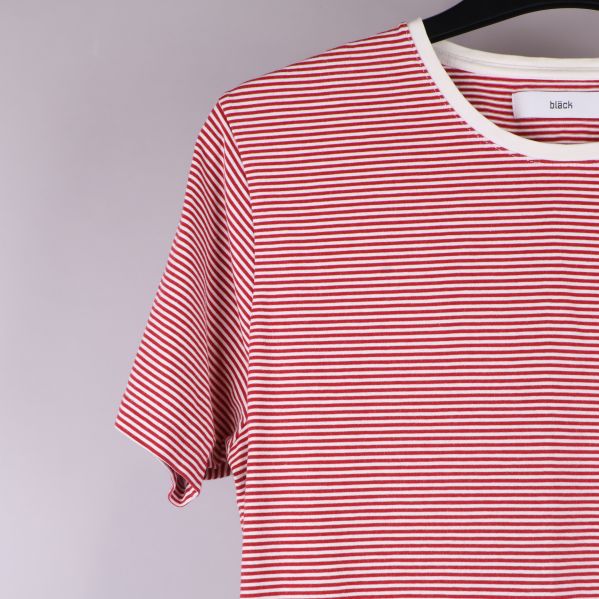 Närbild på ärm och axel av röd- och vitrandig t-shirt