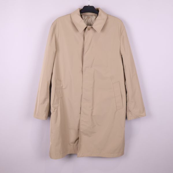 Beige trenchcoat sedd framifrån på galge