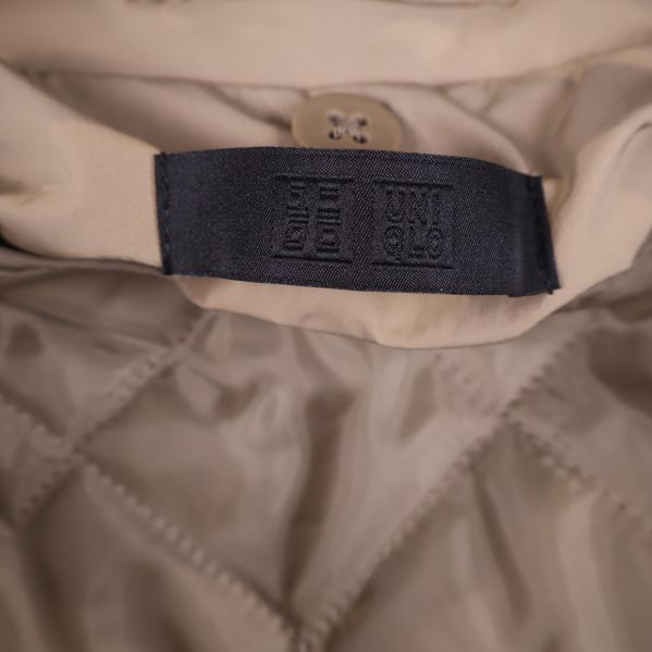 Uniqlo märkesetikett i svart på insidan av jackan