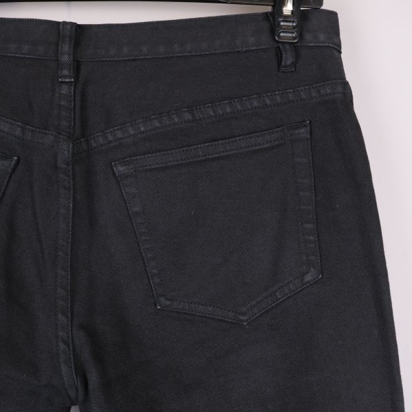 Närbild på bakficka och linning på svarta jeans