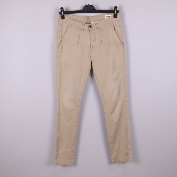 Beiga chinos med sidfickor hängande på galge