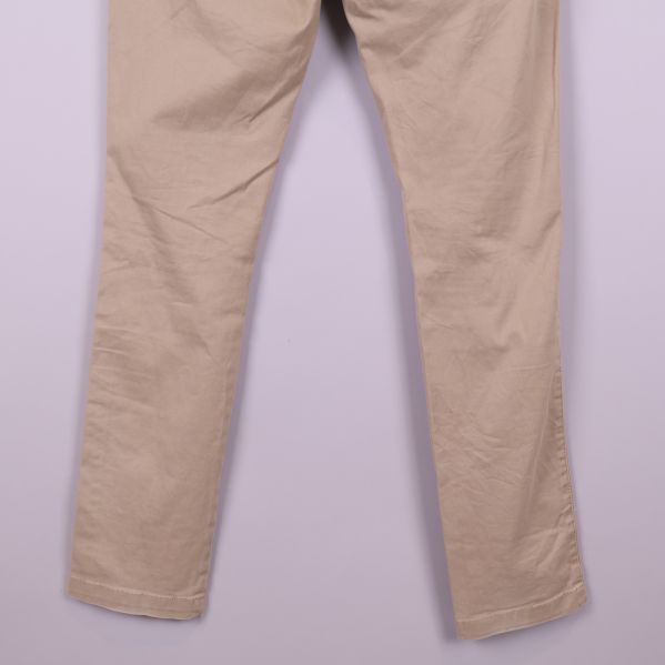 Ben och fotvidd på beiga chinos i närbild