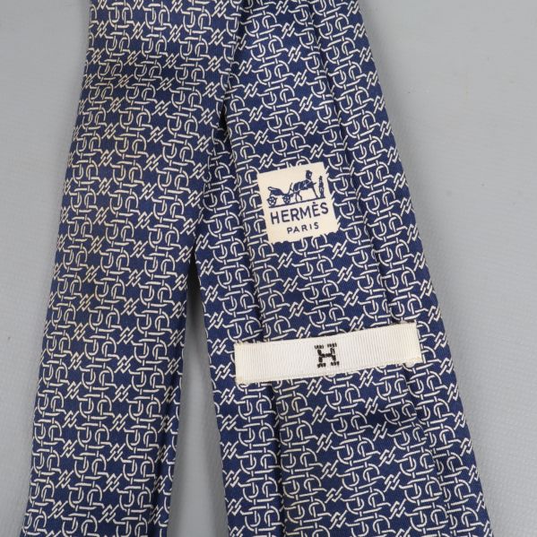 Närbild på Hermès logotyp och mönster på slipsen