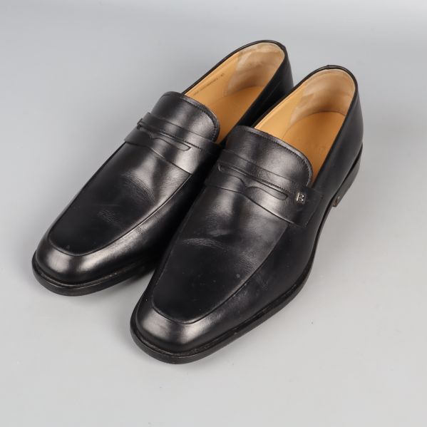 Svarta loafers med pennydetalj i sidan, sidovy