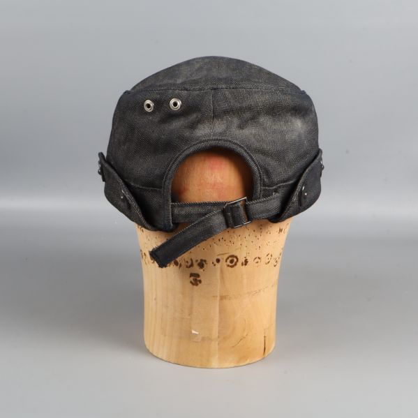 Baksida av kepsen visar justerbart spänne och metallöljetter