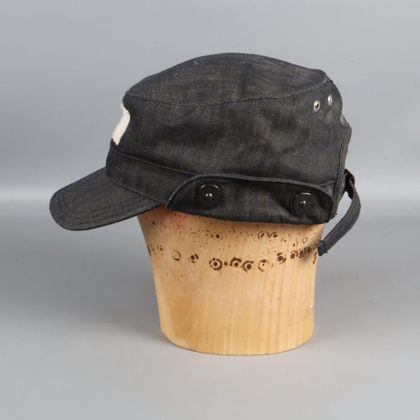 Vänster sida av kepsen med knappar och sömnadsdetaljer