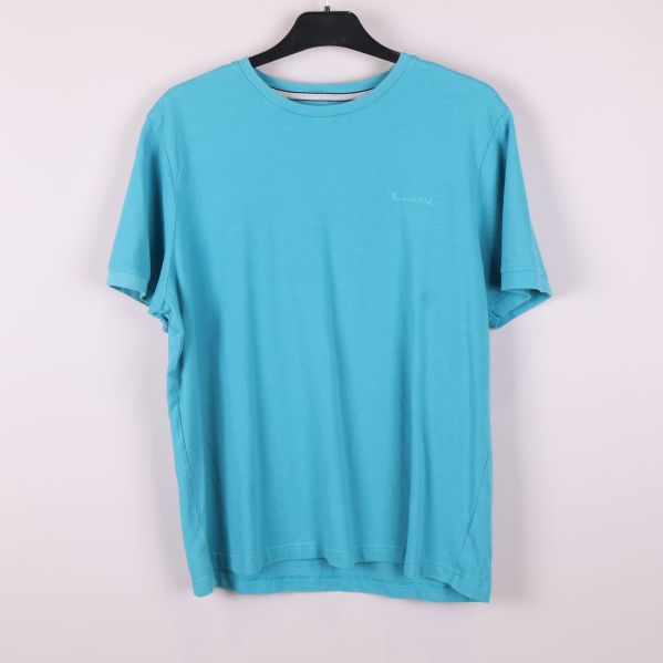 Turkos pique t-shirt hängande på galge framifrån